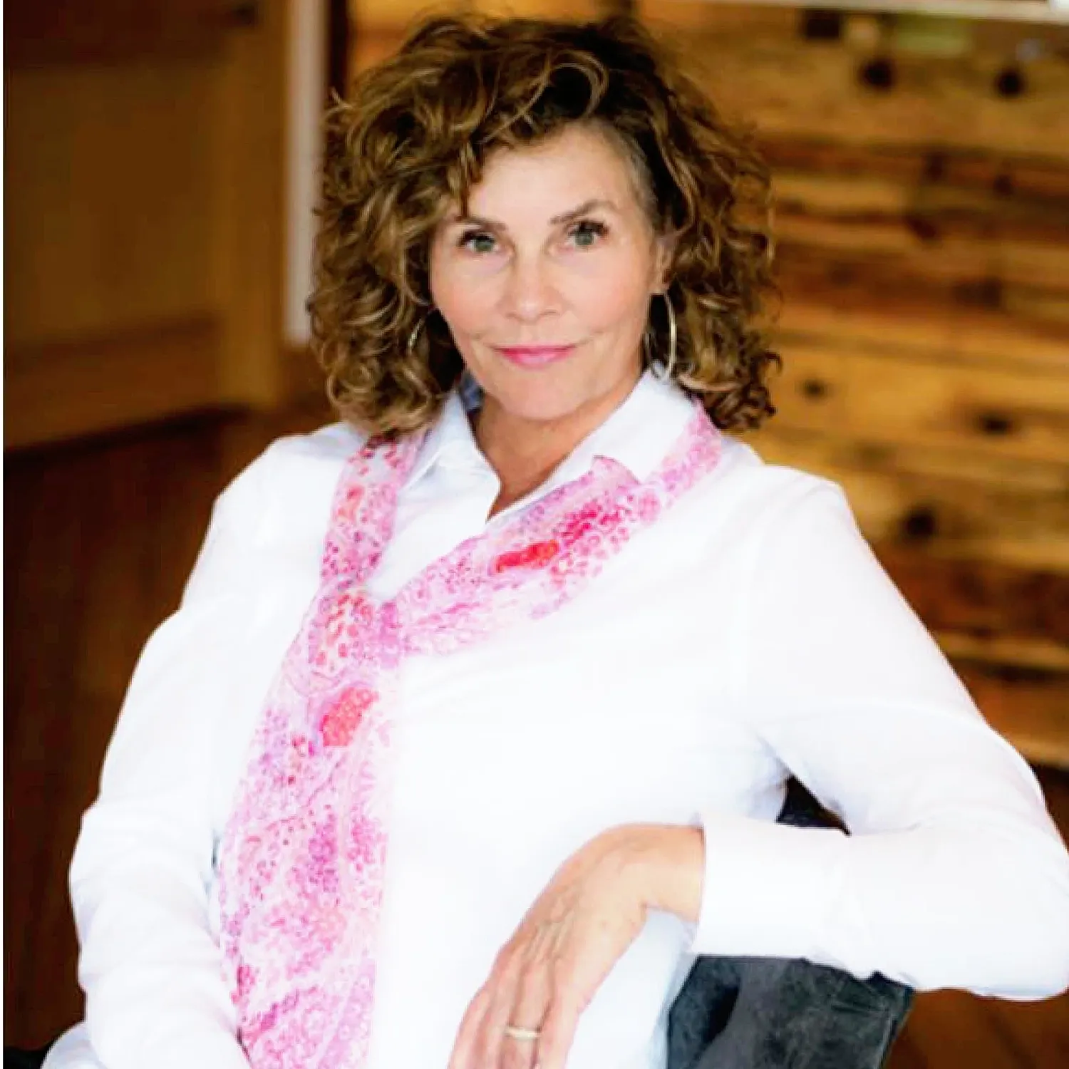 Woman with curly hair in stylish scarf.
