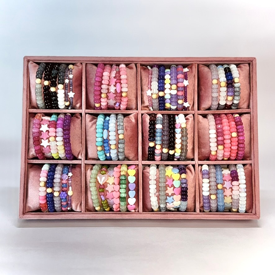 Colorful beaded bracelets arranged in a display box.