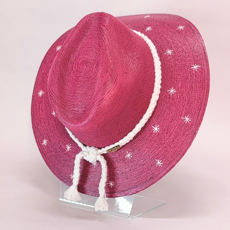 Pink straw hat with white decorative stitching.