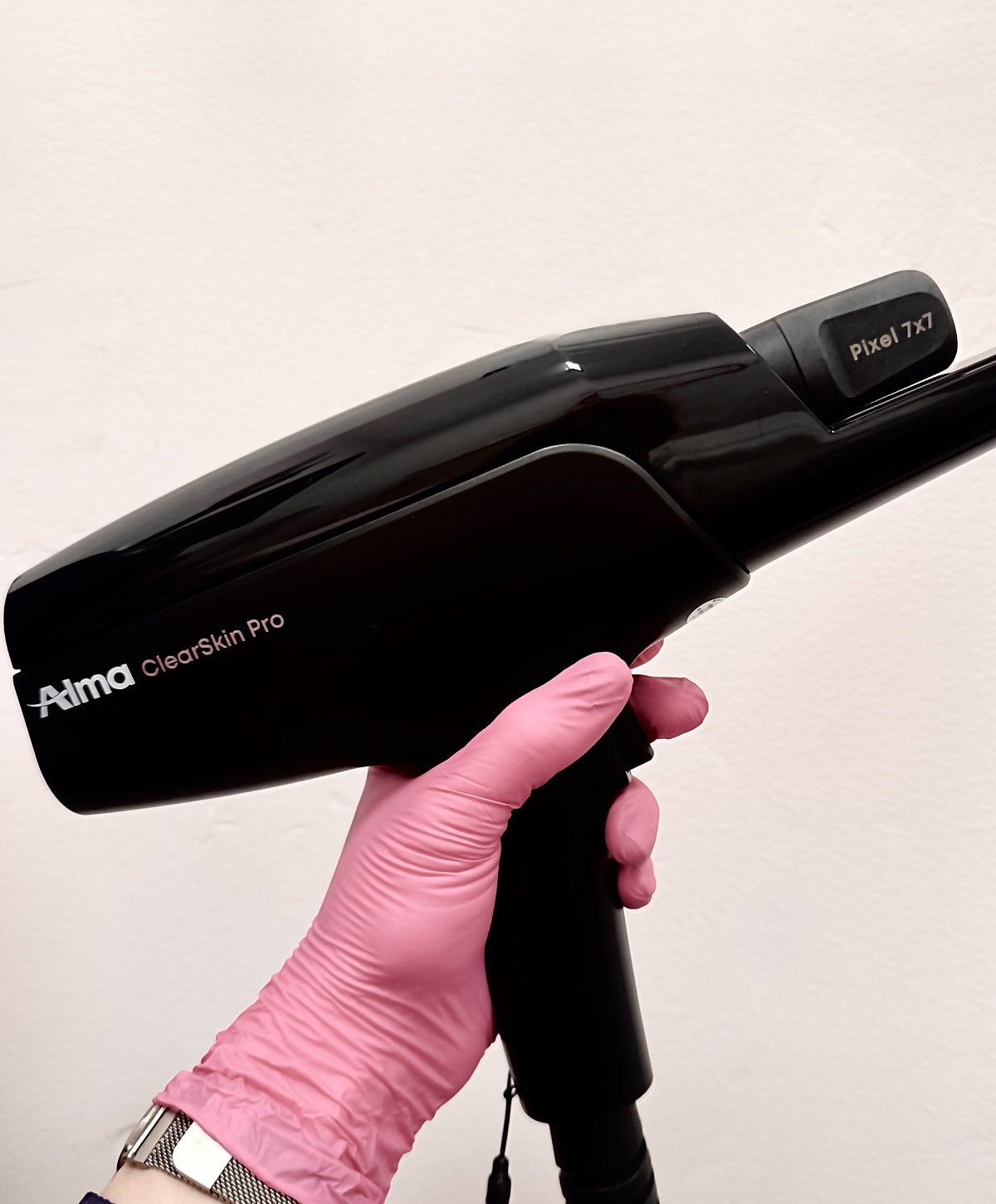 Alma ClearSkin Pro device in gloved hand.