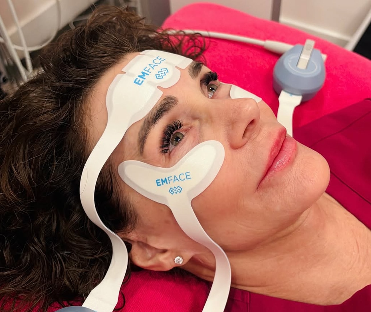 Woman receiving EMFACE facial treatment.