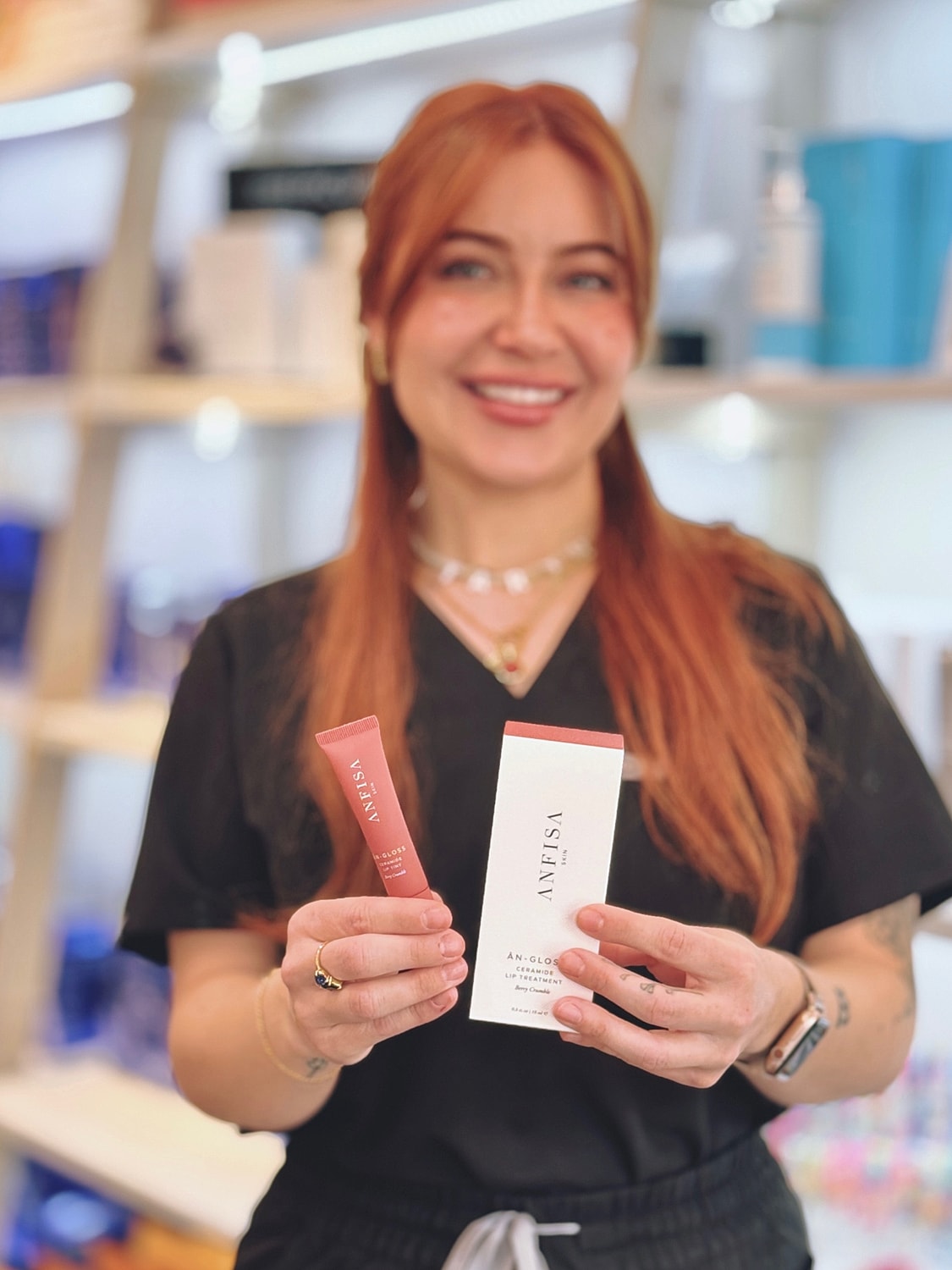 Woman holding ANFISA lip treatment products.
