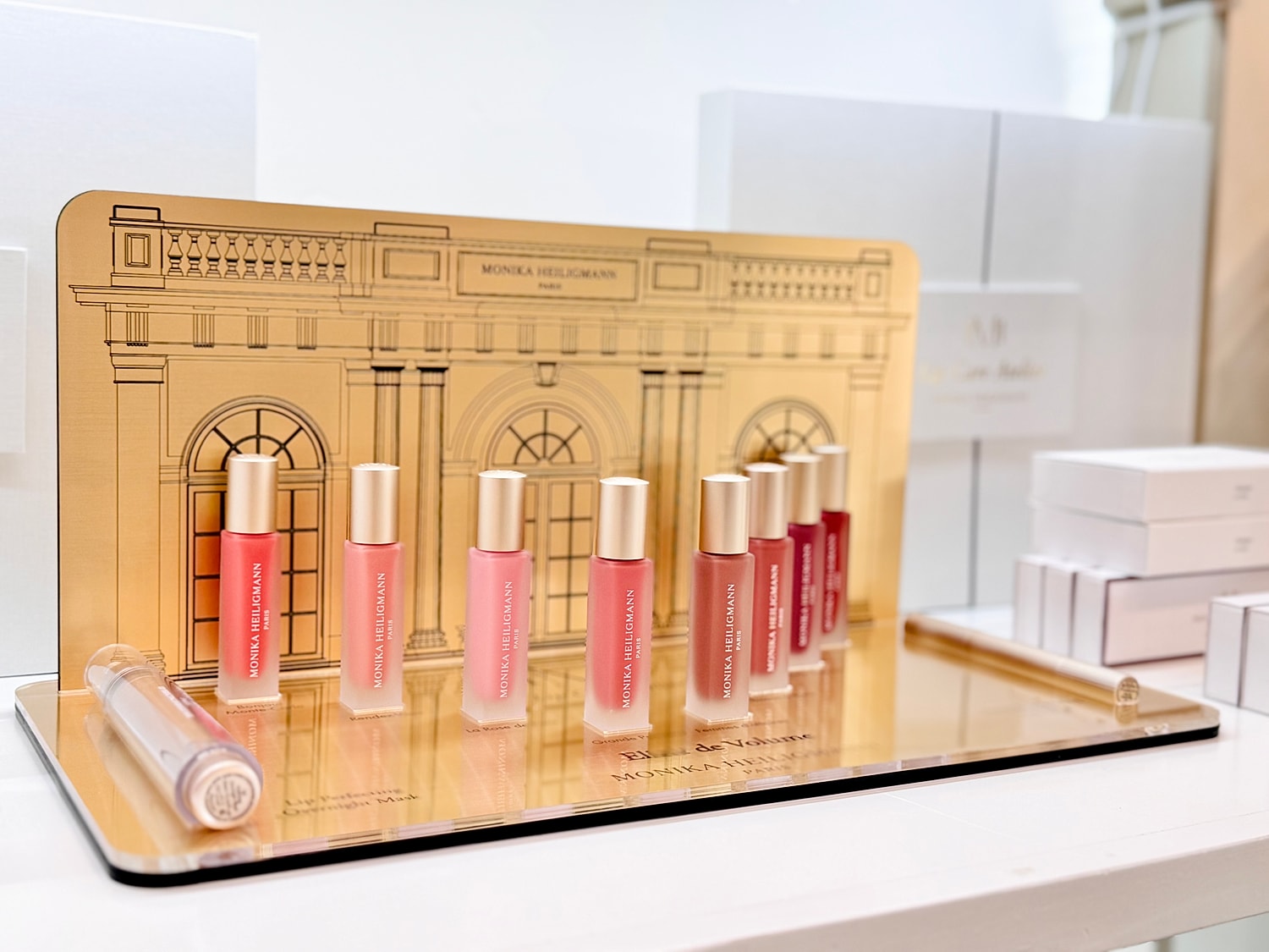 Colorful lip gloss display with elegant background.