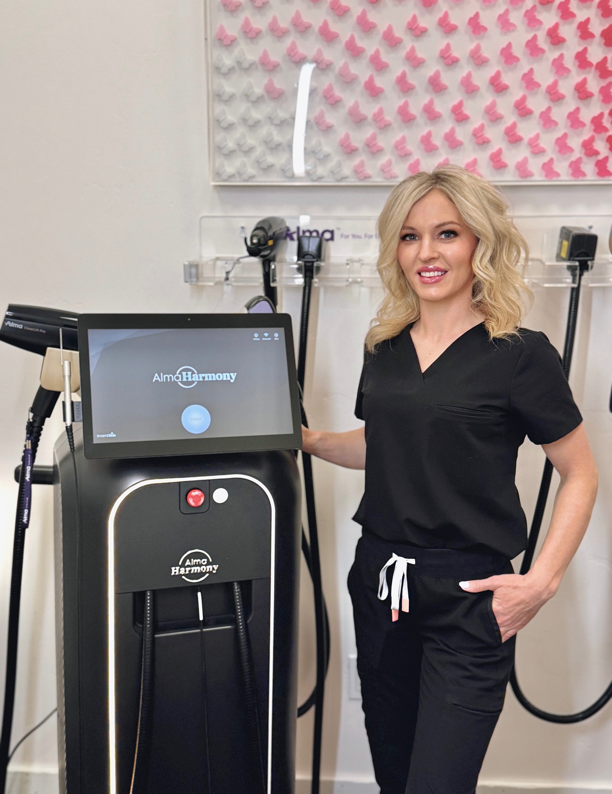 Woman beside Alma Harmony treatment machine